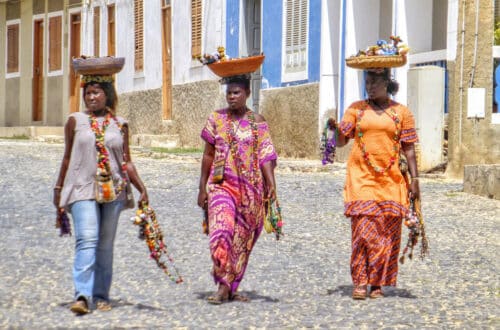 Drei Frauen auf Kapverden balancieren ihre Körbe auf dem Kopf. Foto: Belinda Fewings / Unsplash