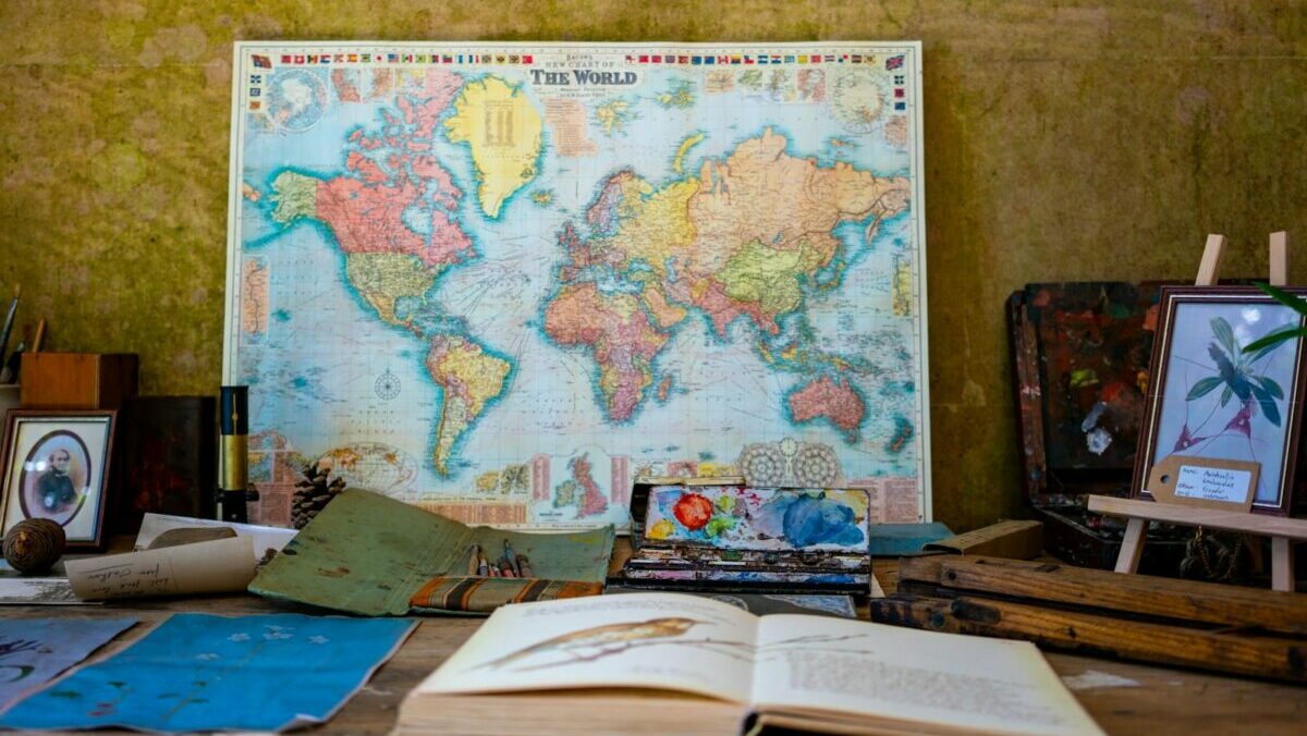 world map poster near book and easel