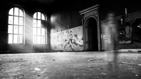 grayscale photo of person standing inside building