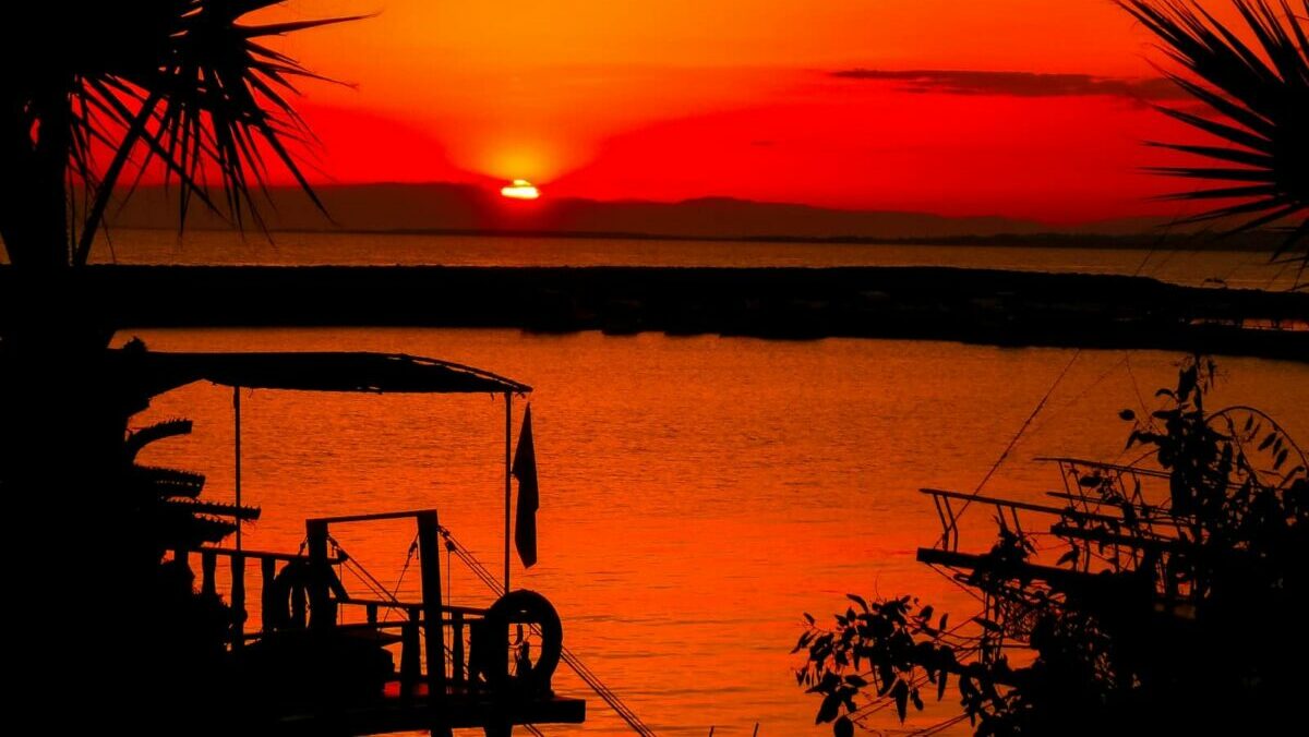 silhouette of people on boat on sea during sunset