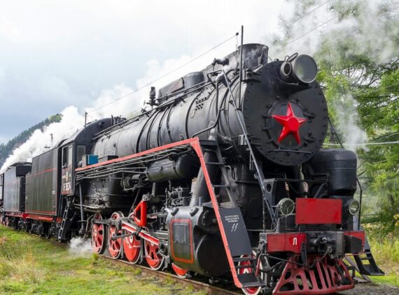 a black and red train traveling down train tracks