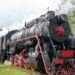 a black and red train traveling down train tracks