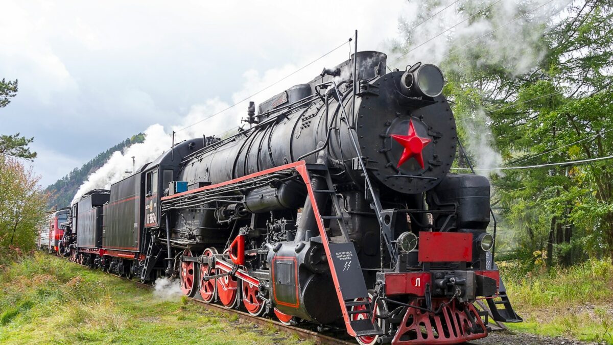 a black and red train traveling down train tracks