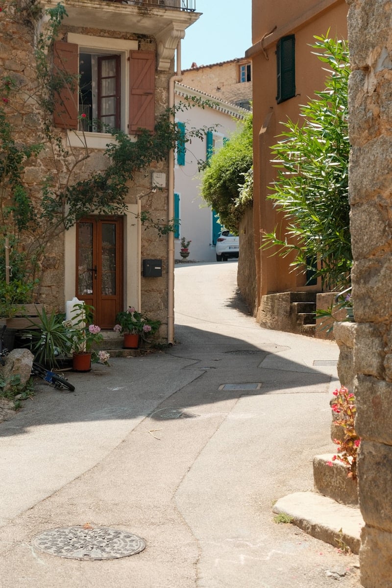 A narrow street with a stone building in the background